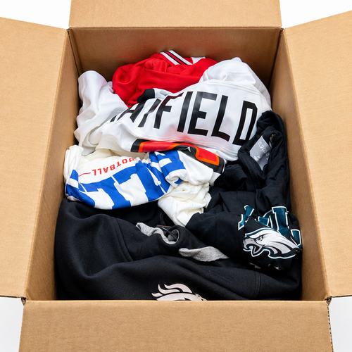 An open Foot Locker Mystery Box showing example athletic apparel and jerseys; actual contents vary